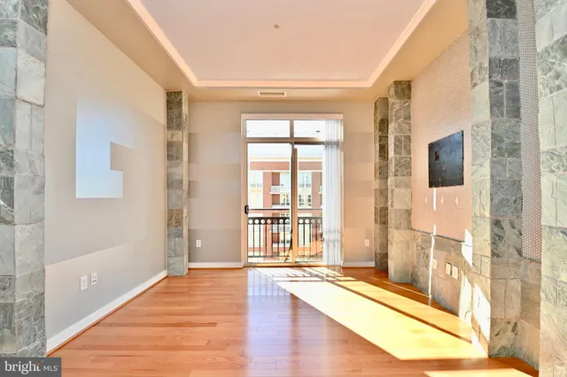 a view of a hallway with wooden floor and a bathroom