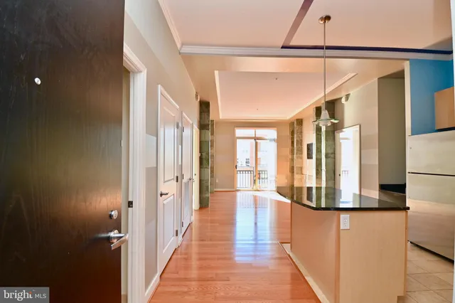 a view of a hallway with wooden floor and staircase