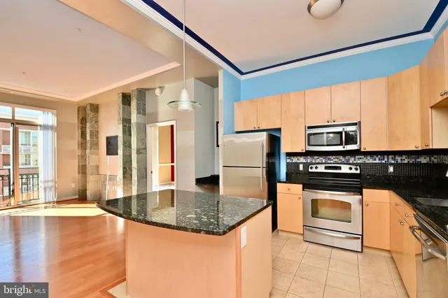 a kitchen with stainless steel appliances granite countertop a stove a refrigerator and a microwave