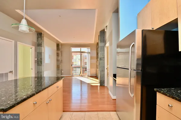 a large white kitchen with granite countertop a refrigerator and a sink