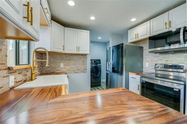a kitchen with stainless steel appliances wooden cabinets a sink and a stove