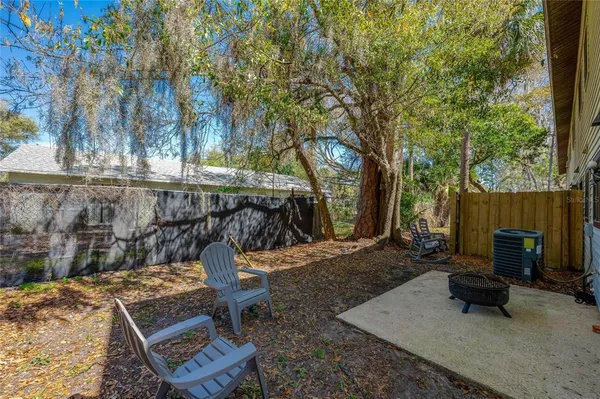 a view of a backyard with chairs and a fire pit