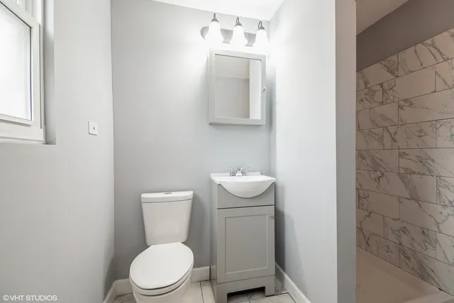 a white toilet sitting next to a bathroom sink