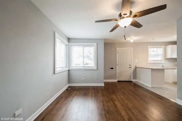 a view of an empty room with window and wooden floor