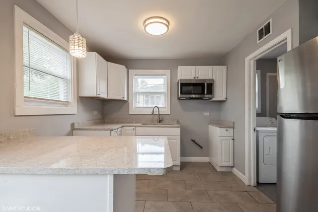 a kitchen with stainless steel appliances granite countertop a refrigerator stove top oven a sink and dishwasher