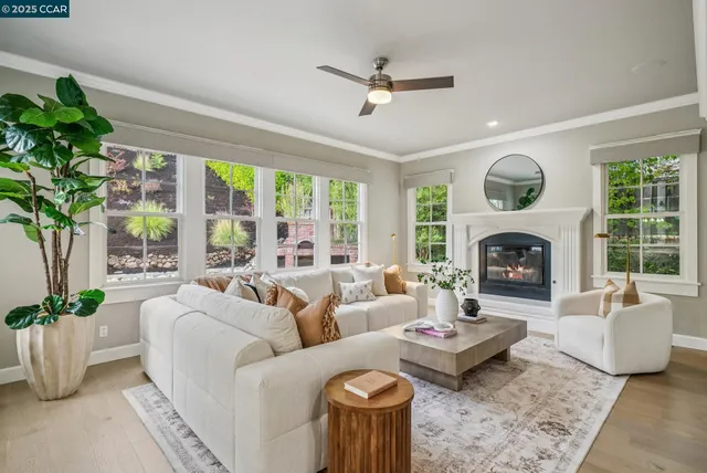 a living room with furniture fireplace and a large window