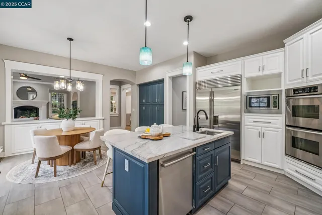 a kitchen with stainless steel appliances granite countertop a stove a sink and a refrigerator