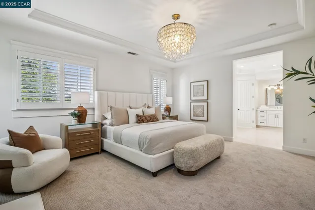 a spacious bedroom with a bed and a chandelier