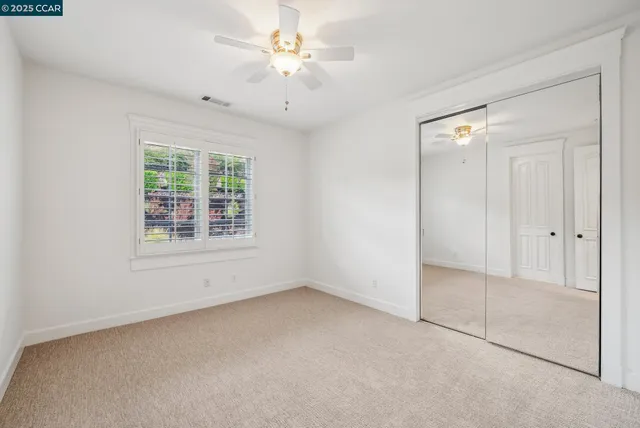 an empty room with chandelier fan