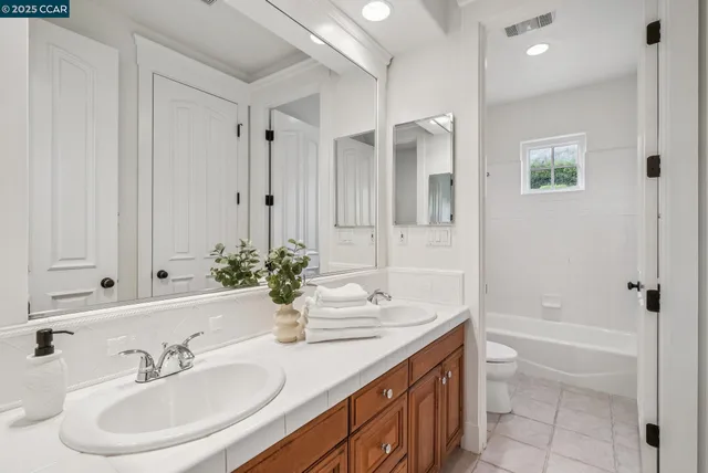 a bathroom with a granite countertop sink a toilet and shower