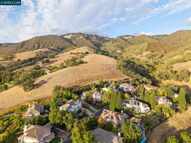 an aerial view of a house with a mountain