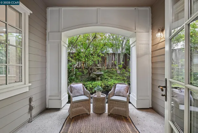 a balcony with chairs and a potted plant