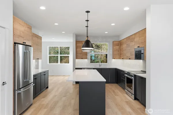 a kitchen with stainless steel appliances granite countertop a stove a sink a refrigerator and a oven