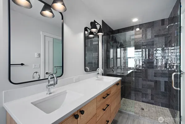 a bathroom with double vanity sink and a mirror