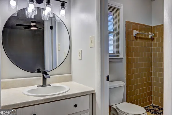 a bathroom with a sink a toilet and a mirror