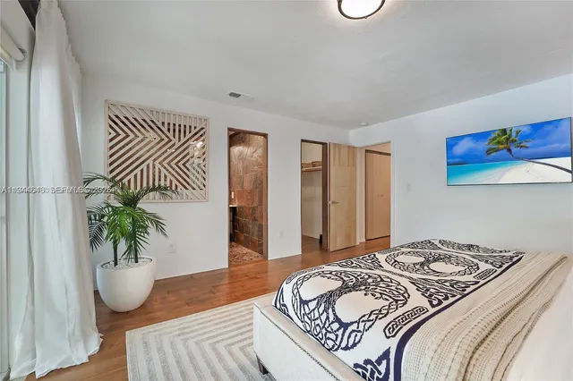 a bedroom with a bed and a potted plant