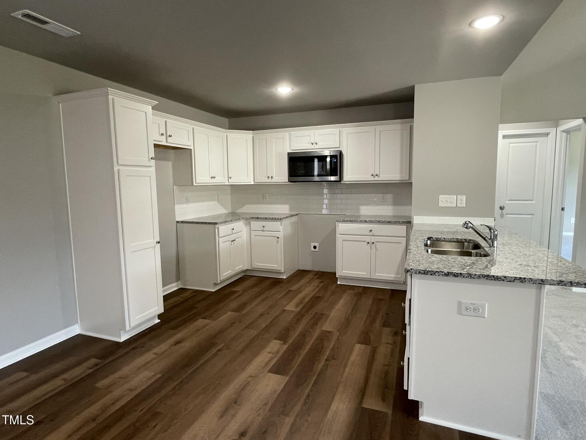 79 Tulipfield Way Benson, NC 27504 - Photo 4 of 19 a kitchen with granite countertop a sink cabinets and stainless steel appliances