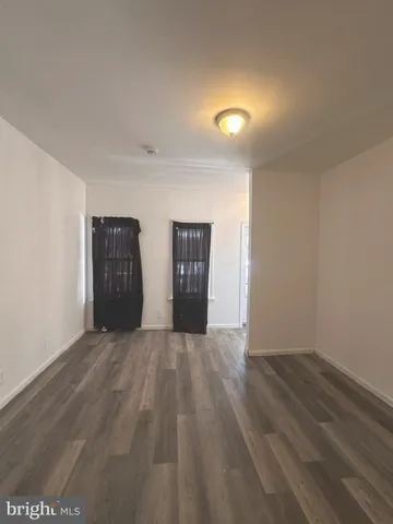 a view of an empty room with closet and a window