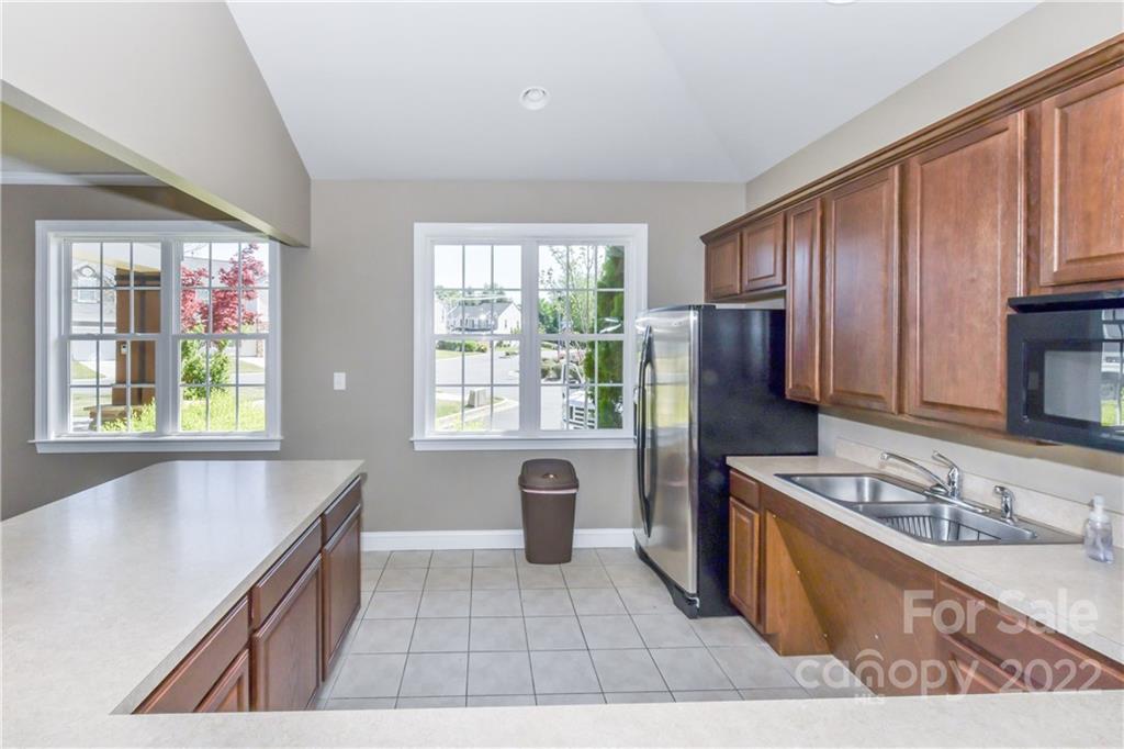 447 Hunters Dance Road, Unit 27 Fort Mill, SC 29708 - Photo 33 of 38 a kitchen with granite countertop a stove a sink and a refrigerator