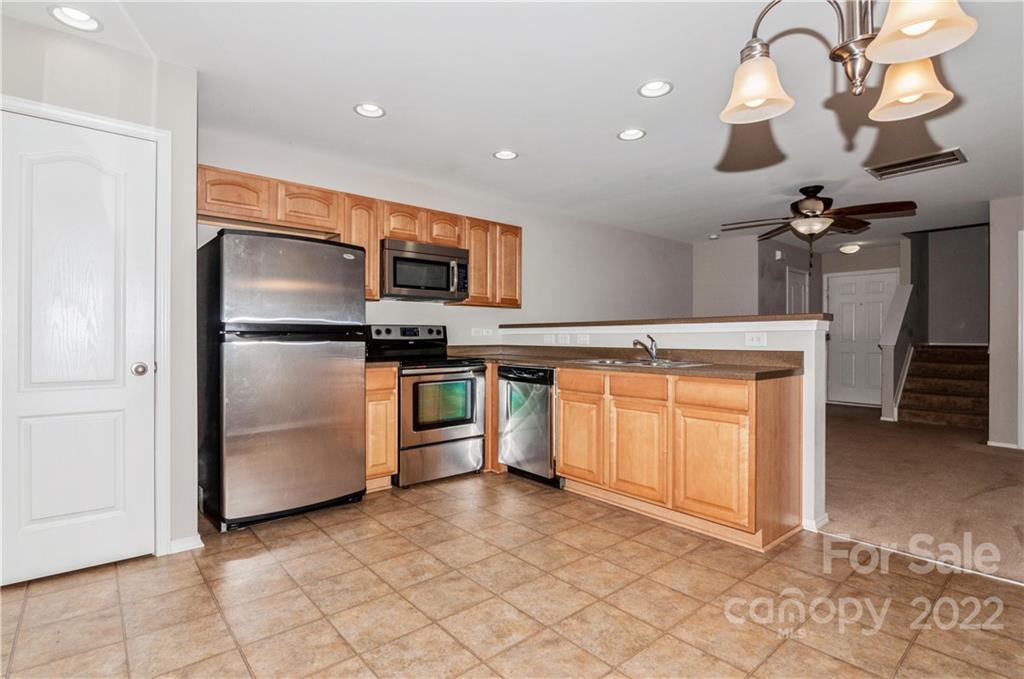447 Hunters Dance Road, Unit 27 Fort Mill, SC 29708 - Photo 6 of 38 a kitchen with stainless steel appliances granite countertop a refrigerator a stove a sink and a microwave