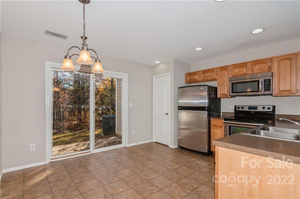 447 Hunters Dance Road, Unit 27 Fort Mill, SC 29708 - Photo 8 of 38 a kitchen with stainless steel appliances granite countertop a refrigerator a stove and a sink with granite countertops