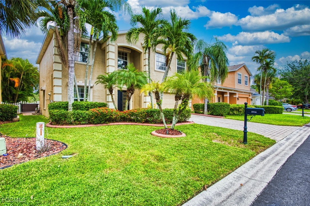8916 Fawn Ridge Drive Fort Myers, FL 33912 - Photo 41 of 49 a view of a house with a yard and palm trees