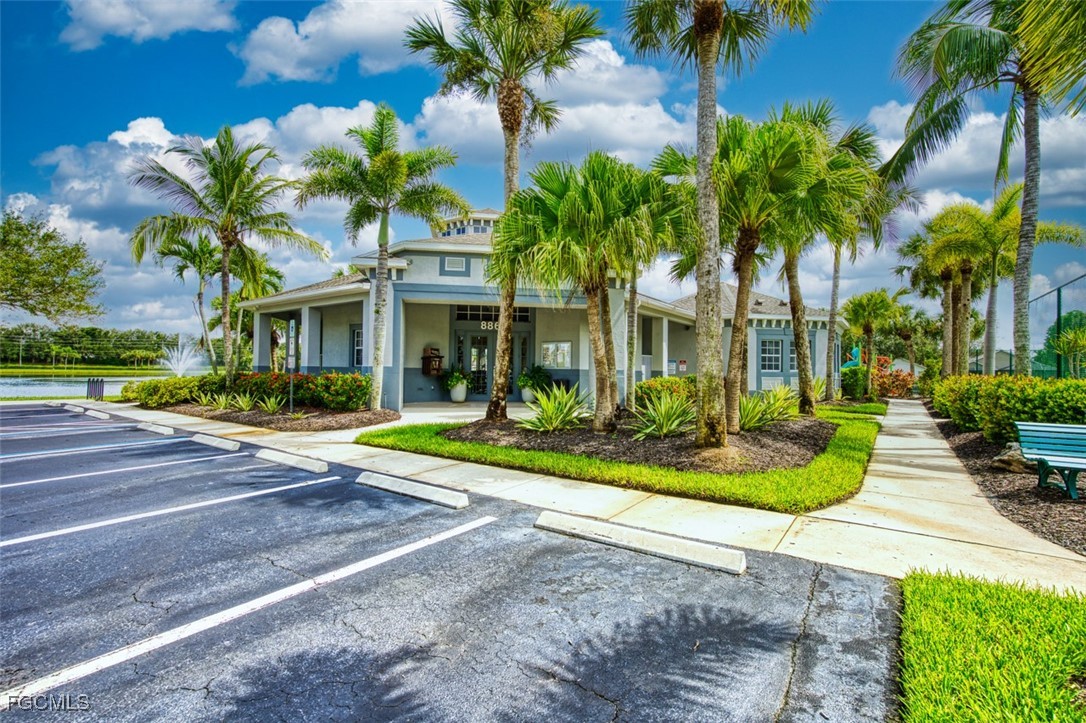 8916 Fawn Ridge Drive Fort Myers, FL 33912 - Photo 42 of 49 a view of a white house with a yard and palm trees