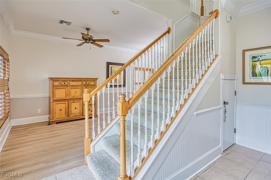 8916 Fawn Ridge Drive Fort Myers, FL 33912 - Photo 6 of 49 a view of staircase with lots of frames on wall and wooden floor