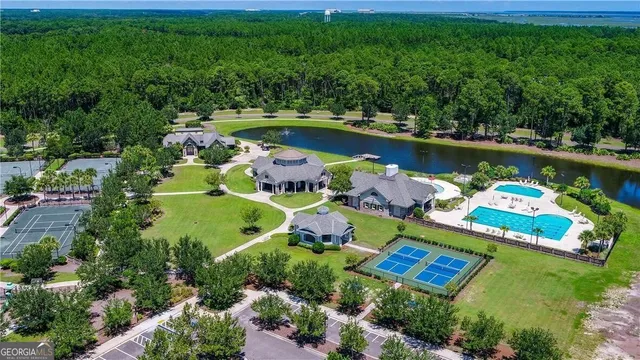 an aerial view of a house with swimming pool a patio and yard