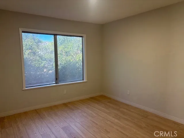a view of a room that has wooden floor and a window