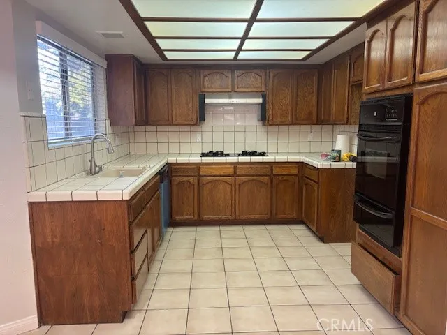 a kitchen with stainless steel appliances granite countertop a sink stove refrigerator and cabinets