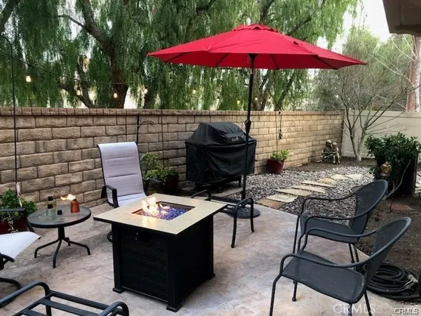 a view of a backyard with furniture and table under an umbrella