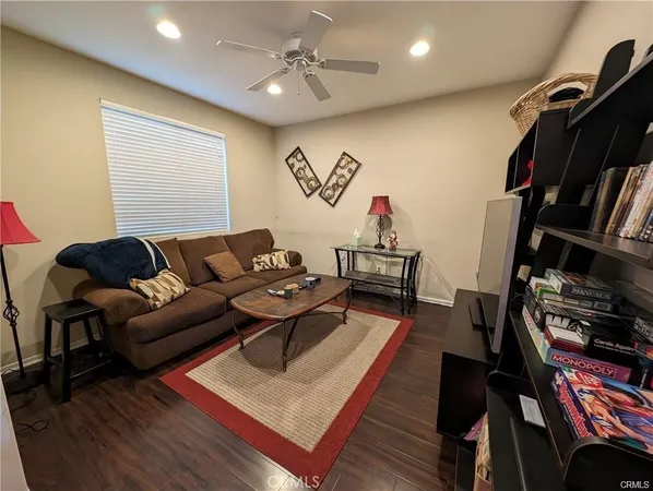 a living room with furniture a rug and a bookshelf