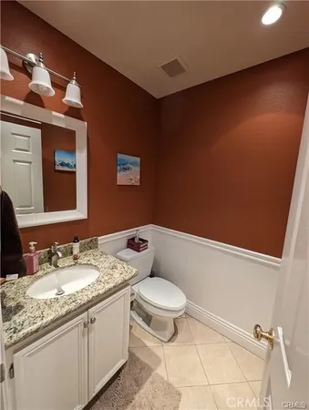 a bathroom with a granite countertop sink a toilet and mirror