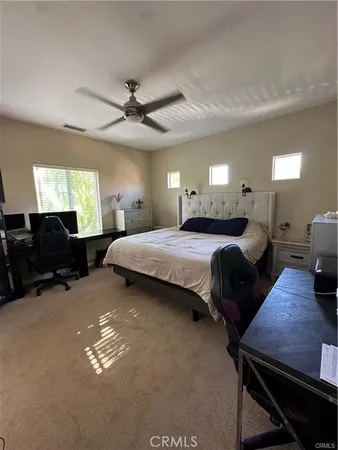 a bedroom with a bed window chandelier and furniture