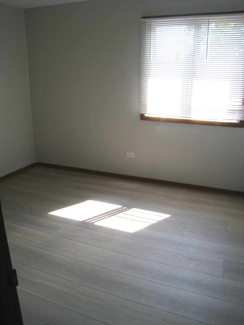 1235 Harding Avenue, Unit 302 Des Plaines, IL 60016 - Photo 12 of 22 a view of an empty room with wooden floor and a window