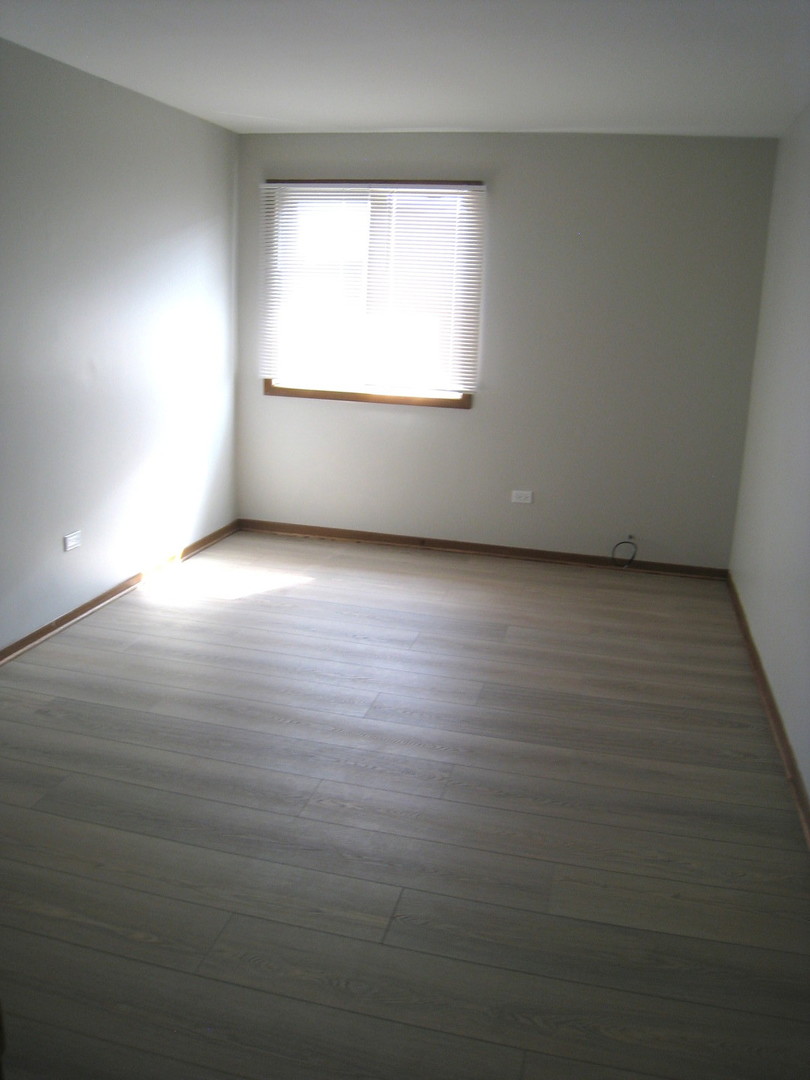 1235 Harding Avenue, Unit 302 Des Plaines, IL 60016 - Photo 14 of 22 an empty room with wooden floor and windows