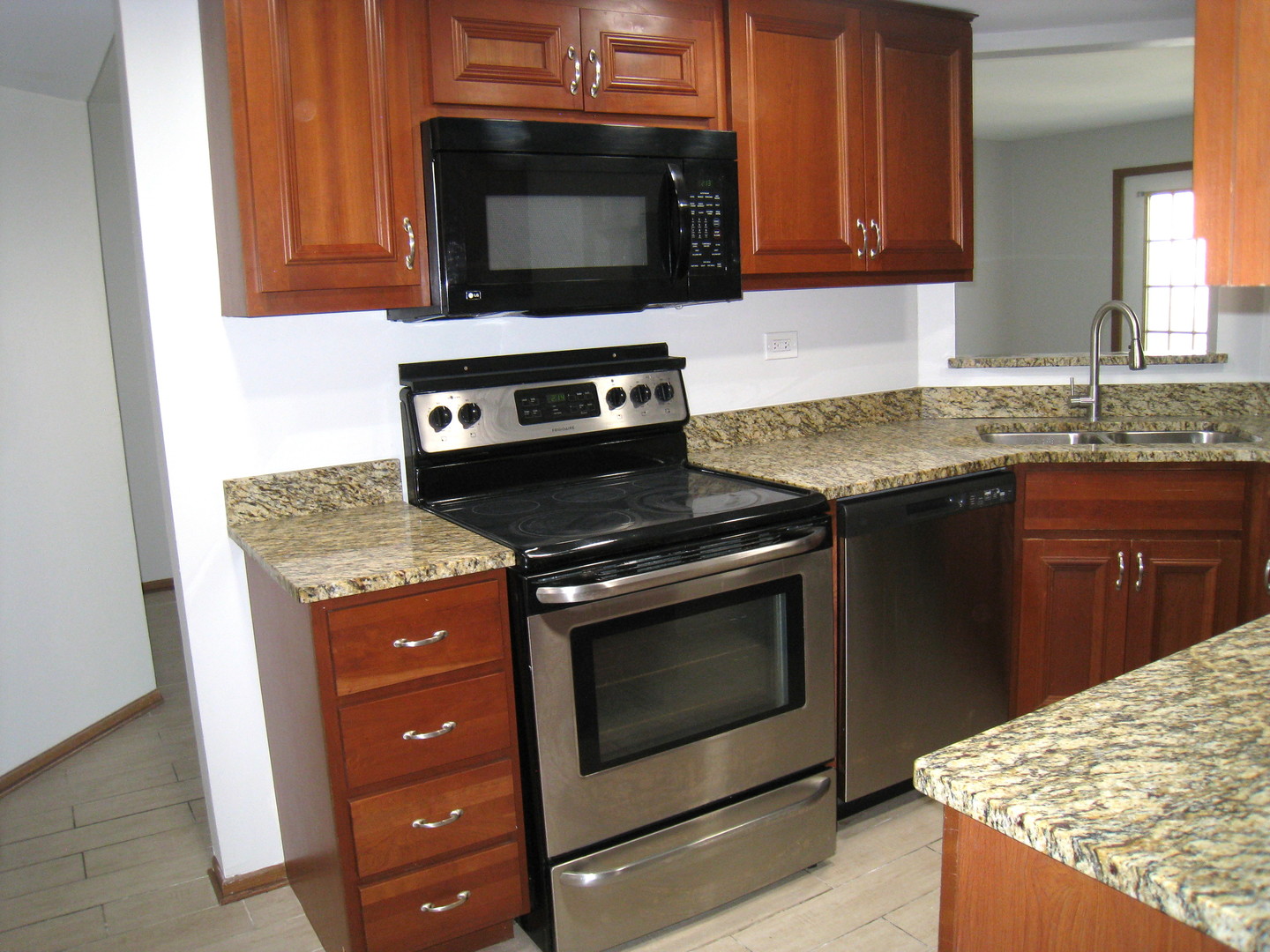 1235 Harding Avenue, Unit 302 Des Plaines, IL 60016 - Photo 3 of 22 a kitchen with granite countertop a stove and a sink