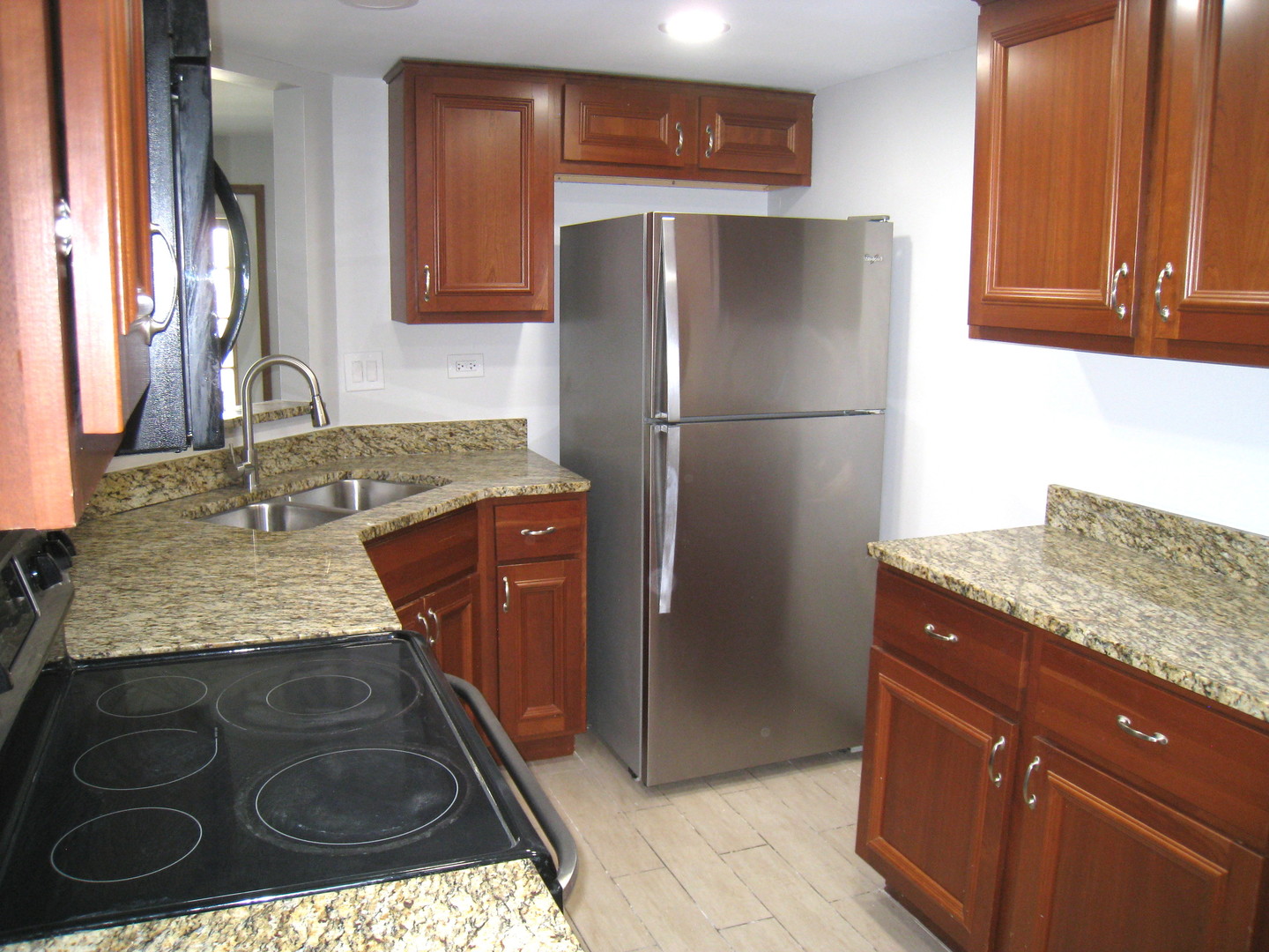 1235 Harding Avenue, Unit 302 Des Plaines, IL 60016 - Photo 4 of 22 a kitchen with granite countertop stainless steel appliances a refrigerator and a sink