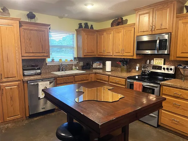 a kitchen with stainless steel appliances a sink a microwave a stove and refrigerator