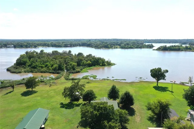 an aerial view of lake and residential houses with outdoor space