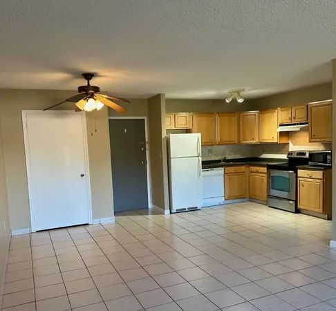 a kitchen with a refrigerator and a stove top oven