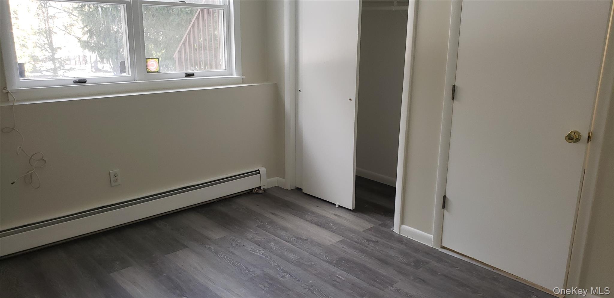 42 Upper Ferndale Road, Unit B Liberty, NY 12754 - Photo 10 of 18 Unfurnished bedroom with baseboard heating, wood finished floors, and a closet