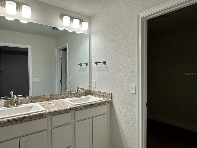 a bathroom with a double vanity sink and a mirror