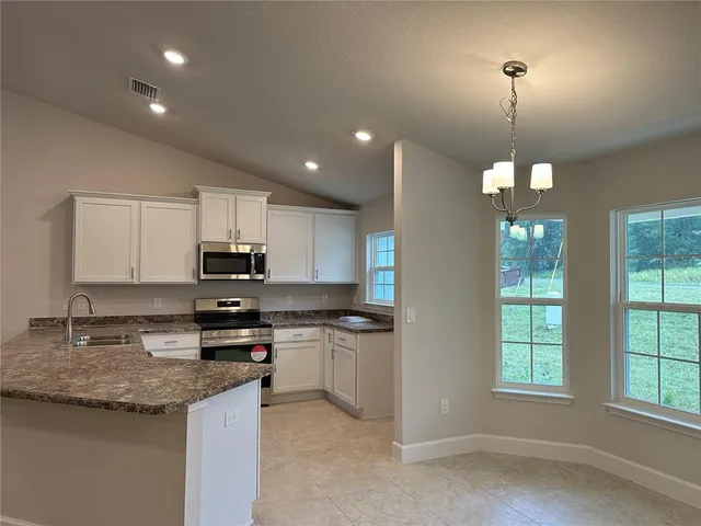 a kitchen with stainless steel appliances granite countertop a sink stove and cabinets