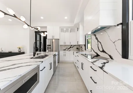 a large white kitchen with a sink a stove and a refrigerator