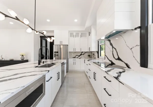 a large white kitchen with a sink a stove and a refrigerator