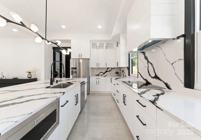 a large white kitchen with a sink a stove and a refrigerator