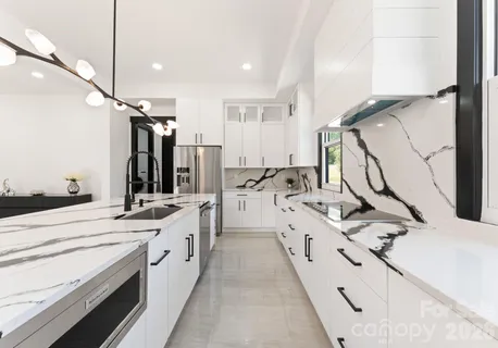 a large white kitchen with a sink a stove and a refrigerator