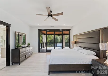 a bedroom with a large bed and windows